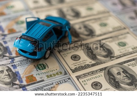 Toy car on one hundred dollar bills.