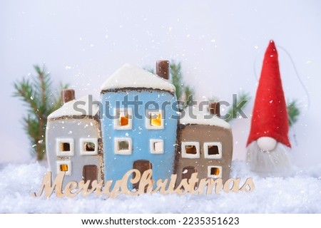 Ceramic house or Christmas toy on blurred background with sparkles. Christmas decor and home decoration for the New Year. Atmospheric mood of the Year 2023. . Close-up