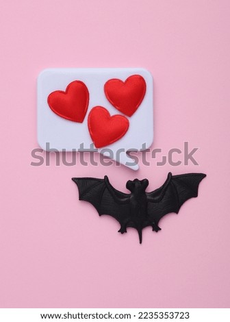 Speech bubble with hearts and a bat on a pink background. Valentine's day, halloween concept