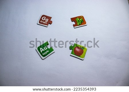Knowledge puzzles with pictures of grapes and apples and words grapes and apples placed on a white background