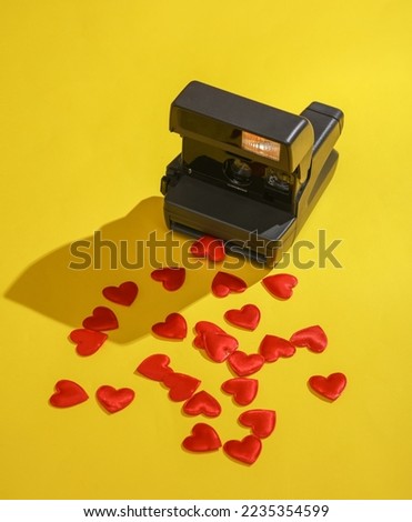Retro instant camera with hearts on a yellow background. Valentine's day, love concept