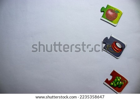 Knowledge puzzles with yoyo picture, grape picture, apple picture placed on the right side of white background