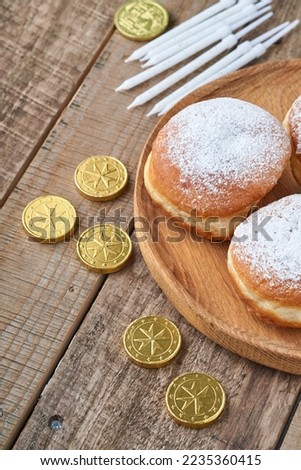 Happy Hanukkah. Hanukkah sweet doughnuts, gift boxes, white candles and chocolate coins on old  wooden background. Image and concept of jewish holiday Hanukkah. Top view.