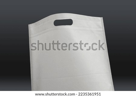 White ECO friendly canvas bag on black background. Shopping bag. Promotion and Presentation Bag. Non Woven Polypropylene Bag with black background. Reusable Biodegradable empty handle loop item
