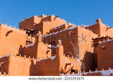 Winter scene of snow-covered adobe pueblo style building in Santa Fe, New Mexico Royalty-Free Stock Photo #2235391875