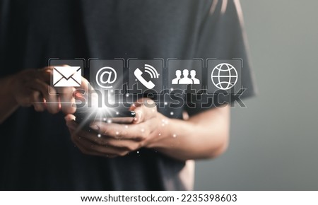 Businessman using laptop pc with contact icons on virtual screen. searching web, browsing information, Contact us or Customer support hotline people connect.