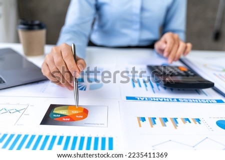 Asian business ideas are thinking and calculating with a calculator. front view of hand pointing to business data chart to calculate analysis Company financial processing.