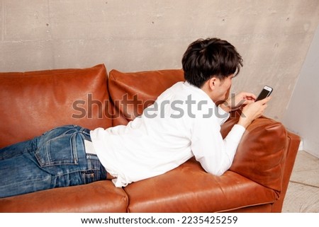 man looking at smartphone in room Royalty-Free Stock Photo #2235425259