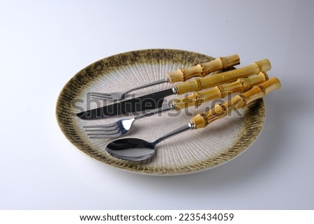 Cutlery or flatware on rustic plate with bright background. Sendok garpu pisau atau peratan makan