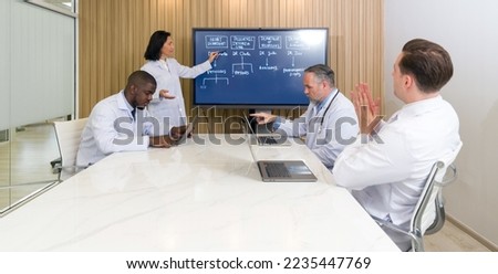 Director of various departments in the hospital attend the annual meeting. The meeting leader use a flat screen TV for presentations. Everyone have their own laptop computer.