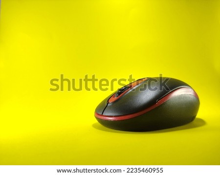 shot of black laptop mouse on yellow background
