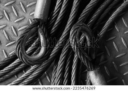 Iron wire rope placed on striped steel plate. Black and white photo. Conceptual images of blockchain, human connection and solid fixation.