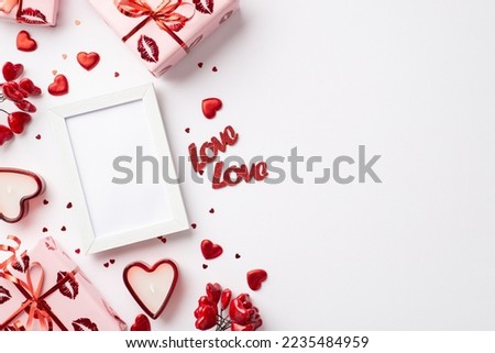 Valentine's Day concept. Top view photo of photo frame gift boxes in wrapping paper with kiss lips pattern red hearts confetti inscriptions love candles on isolated white background with blank space