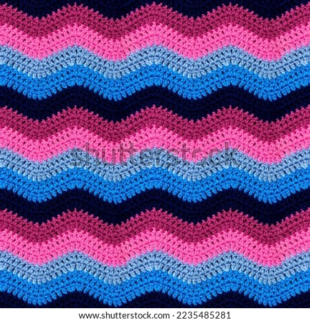 Seamless crochet zigzag pattern is crocheted with bright contrasting threads. Acrylic baby yarn. African style. Blue and pink color scheme. Royalty-Free Stock Photo #2235485281