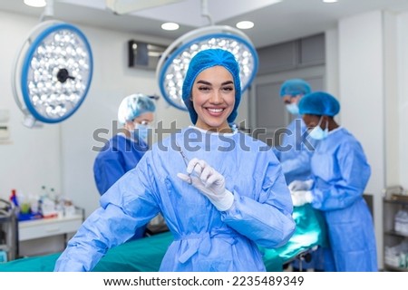Portrait of female woman nurse surgeon OR staff member dressed in surgical scrubs gown mask and hair net in hospital operating room theater