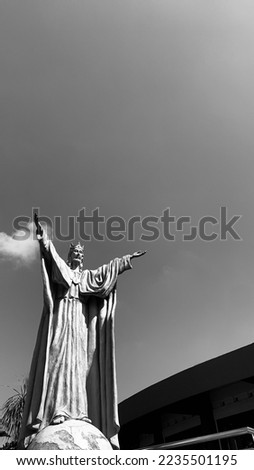 Jesus christ statue in front of a church in Indonesia. Capture this picture in black-and-white mode. 