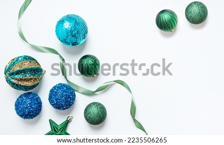 green and blue christmas decorations with satin ribbon isolated on white background. top view. copy space. flat lay.