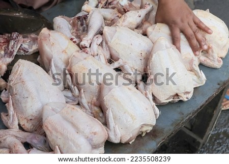 broiler market activity. is cutting fresh chicken on the table.
