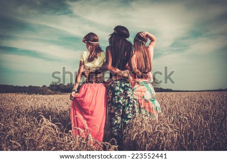 Multi-ethnic hippie girls  in a wheat field  Royalty-Free Stock Photo #223552441