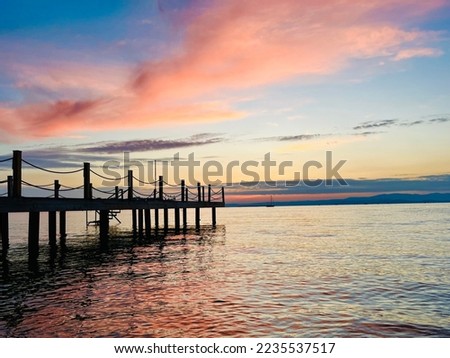 Tender heavens reflection on the sea surface, tender colors, twilights, wooden pier at the sea, silhouette of the pier Royalty-Free Stock Photo #2235537517