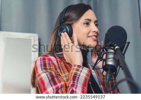 A girl radio host with headphones broadcasting with a studio microphone. Stream, live broadcast, blogging concepts. High quality photo