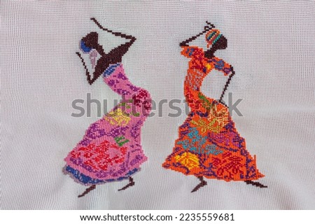 Handmade embroidery. Multicolored patterns on white fabric. Ethnic drawing. Copy space.