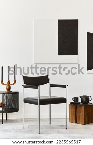 Interior design of modern living room with black stylish commode, chair, mock up art paintings, lamp, book, candlestick, decorations and elegant accessories in home decor. Template.