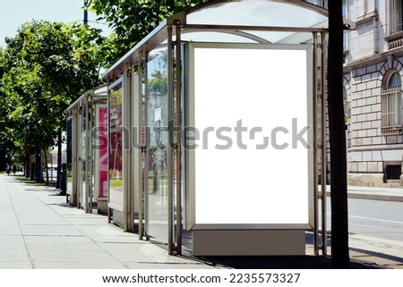 bus shelter, busstop. blank white lightbox. empty billboard. bus shelter advertising. glass structure. transit station. urban setting. European city street background. stone sidewalk. base for mockup