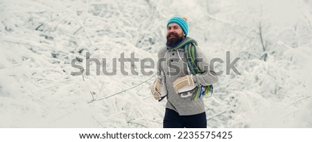 Winter banner. Bearded man walking on snow park outdoor. Funny winter guy is going skate outdoors. Winter man portrait for banner.