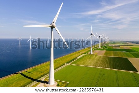 windmills turbines and a blue sky generating electricity green energy energy transition Royalty-Free Stock Photo #2235576431