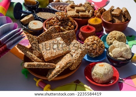 Indian festival makar sankranti special haldi kumkum with sankranti sweets of jaggery recipes, til ladoo, peanut chikki, til chikki, rajgira laddu Royalty-Free Stock Photo #2235584419