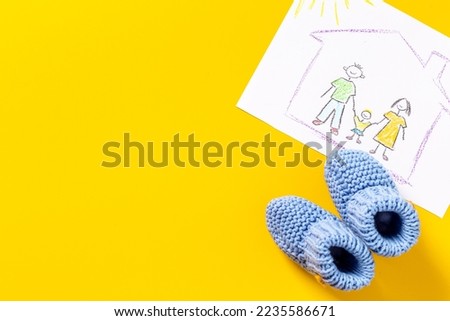 Childrens pencil drawing of family with booties. Adoption concept. Top view