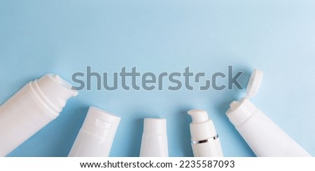 Photography from above of the blank cosmetics containers on blue background.