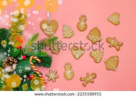 Banner with Christmas gingerbread and Christmas tree branches on a pink background. Place for text on top. The concept of festive New Year's baking