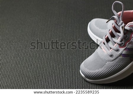 Grey Sport shoes on sport mattress. Indoor workout concept and healthy lifestyle. Sport equipment background. Copy space for text.