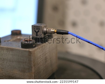 Triaxial accelerometer stuck on steel cube, screwed on an electrodynamic shaker. Royalty-Free Stock Photo #2235599147