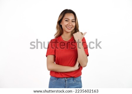 Studio shot of pretty Asian woman with red t-shirt isolated on white background. Pointing blank area