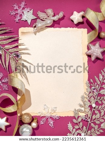 Christmas letter with shiny branches and decoration toys on pink background. Merry Christmas and Happy New Year concept. Copy space for your text. Top view