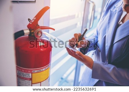 woman worker inspection chemical Fire extinguisher and fire hose. writing on monthly check document. Selected focus Royalty-Free Stock Photo #2235632691
