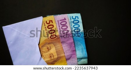 5000, 10000 and 50000 rupiah banknote isolated on black background. Photo taken from a top angle