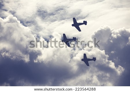 Old fighter planes on bright cloudy sky