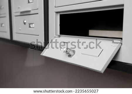 Open empty metal mailbox with keyhole indoors Royalty-Free Stock Photo #2235655027