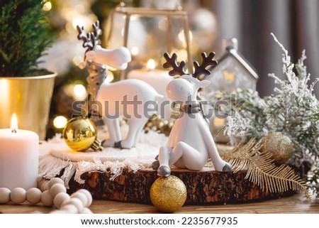 Happy New Year 2023. Christmas card with cute reindeer on a beautiful bokeh background. New Year's still life. The concept of a home holiday, warmth and comfort.