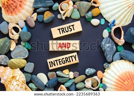 Trust and integrity symbol. Concept words Trust and integrity on wooden blocks. Sea stone, seashell. Beautiful black background. Business, psychological and trust and integrity concept. Copy space.