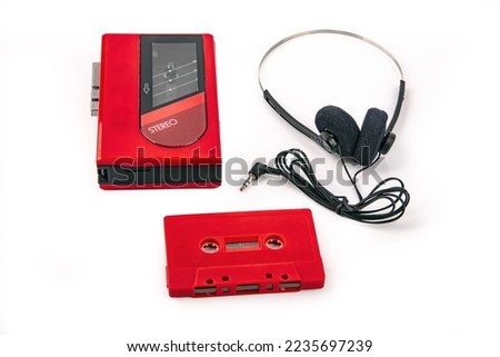Red Walkman with Headphone and Tape isolated on bright background Royalty-Free Stock Photo #2235697239