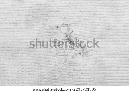 White Old Hole Torn Ripped Material Surface Texture Vintage Textile Worn Fabric Background. Royalty-Free Stock Photo #2235701905