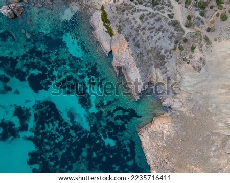 Aerial views with a 4k drone, in a centinal direction of rocks and sea where you can appreciate the colors, contrasts and textures that the Mediterranean seas of the Balearic coast, Europe.