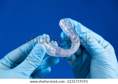 Dental transparent plastic mouthguard, splint for the treatment of dysfunction of the temporomandibular joints, bruxism, malocclusion, to relax the muscles of the jaw Royalty-Free Stock Photo #2235719591
