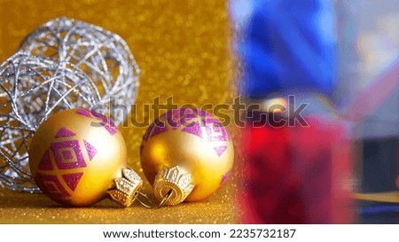 Christmas decorations - balls and a glass prism on a sparkling golden background. Winter holidays and preparation for christmas and new year. For a greeting card. Selective focus. Close-up