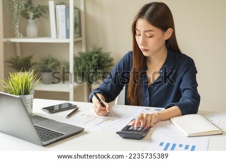 Account finance, analysis asian business woman hand use pen for calculate budget, cost and income of company from on charts, reports paperwork, plan spend money expenses, working on desk at home. Royalty-Free Stock Photo #2235735389